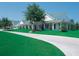 White building with green roof, landscaping, and a paved pathway at 2615 Kinsale Ln, Ormond Beach, FL 32174