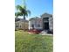 One-story house with a two-car garage and palm trees in the front yard at 10198 Oak Crest Rd, Orlando, FL 32829