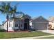 One-story house with a two-car garage and attractive landscaping, featuring palm trees at 10198 Oak Crest Rd, Orlando, FL 32829