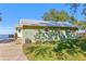 Green house exterior with a metal roof, wooden steps, and a spacious yard at 3420 Lake Harney Cir, Geneva, FL 32732
