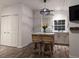 Bright kitchen with white cabinets, island with seating, and wood-look floors at 3420 Lake Harney Cir, Geneva, FL 32732