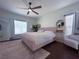 Spacious main bedroom with a plush pink bed and a ceiling fan at 402 Blue Lake Cir, Kissimmee, FL 34758