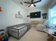 Bright room featuring a crib, recliner, and large TV at 402 Blue Lake Cir, Kissimmee, FL 34758