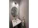 Small bathroom with pedestal sink, oval mirror, and white vanity at 556 Lake Wildmere Cv, Longwood, FL 32750
