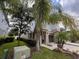 Landscaped front yard with palm trees and shrubs near the house at 556 Lake Wildmere Cv, Longwood, FL 32750