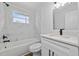 Modern bathroom with white cabinets, marble tile, and a bathtub at 603 Conrad Dr, New Smyrna Beach, FL 32168