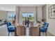 Bright dining room with glass table and blue chairs, overlooking a backyard at 7140 Painted Bunting Way, St Cloud, FL 34773