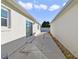 Side yard with small patio and access to the house at 1306 Loma Ln, The Villages, FL 32159