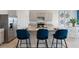 Modern kitchen island with blue velvet stools and granite countertop at 4807 Khloe Ct, Winter Haven, FL 33884