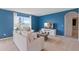 Living room with light couch, blue walls, and view to bathroom at 4807 Khloe Ct, Winter Haven, FL 33884
