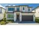 Two-story house with gray and white exterior, dark garage door, and landscaped yard at 6240 Sand Skipper Rd, Orlando, FL 32821