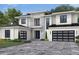 Two-story home with white siding, black garage doors, and a stone accent wall at 9144 Sheen Sound, Orlando, FL 32836