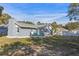 Charming backyard with a large grassy area and a gray house at 27623 Lisa Dr, Tavares, FL 32778