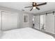 Main bedroom with white bedding, a ceiling fan, and an ensuite bathroom at 27623 Lisa Dr, Tavares, FL 32778