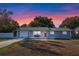 Newly renovated 1-story home with gray exterior, red door, and attached garage at 27623 Lisa Dr, Tavares, FL 32778
