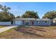Newly renovated home with gray exterior, red door, and a long driveway at 27623 Lisa Dr, Tavares, FL 32778