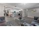 Spacious living room with gray sofas, glass coffee table, and view into kitchen at 27623 Lisa Dr, Tavares, FL 32778