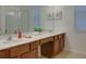 Double vanity bathroom with wood cabinets and a walk-in shower at 4565 Cabello Loop, Kissimmee, FL 34746