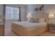 Bedroom with a king-size bed, light beige headboard and nightstands with lamps at 4565 Cabello Loop, Kissimmee, FL 34746