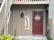 Condo entrance with a red door and festive decorations at 5787 Peregrine Ave # C09, Orlando, FL 32819