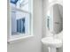 Powder room featuring a pedestal sink, oval mirror, and window at 6553 Rover Way, Saint Cloud, FL 34771