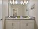 Bathroom with double vanity, large mirror, and bright lighting at 830 Pebble Beach Dr, Davenport, FL 33896