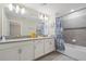 Bathroom with double vanity, bathtub, and gray tile at 830 Pebble Beach Dr, Davenport, FL 33896