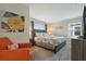 Bedroom with a queen bed, dresser, and an orange armchair at 830 Pebble Beach Dr, Davenport, FL 33896