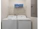 Convenient laundry room with washer, dryer, and shelving at 830 Pebble Beach Dr, Davenport, FL 33896
