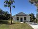 Newly constructed home with a white exterior, teal door, and palm tree at 991 S Delaware Ave, Deland, FL 32720