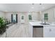 Open concept kitchen with white cabinets, stainless steel appliances, and island at 991 S Delaware Ave, Deland, FL 32720