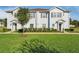 Two-story townhome with light-colored siding, brown shutters, and a well-manicured lawn at 3212 Cupid Pl, Kissimmee, FL 34747