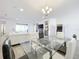 Open dining room with glass table, chandelier, and kitchen view at 4408 Renly Ln, Clermont, FL 34711