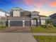Two-story home with three-car garage and landscaped yard at 4408 Renly Ln, Clermont, FL 34711