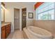 Elegant bathroom with soaking tub, walk-in shower, and granite vanity at 7513 Excitement Dr, Reunion, FL 34747
