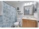 Small bathroom with wood vanity, shower/tub combo, and a mirror at 7606 Acklins Rd, Kissimmee, FL 34747