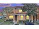 Two-story townhome exterior at dusk, showing warm lighting in the windows at 7606 Acklins Rd, Kissimmee, FL 34747