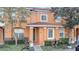 Front view of a two-story townhome with a dark brown door and well-maintained landscaping at 7606 Acklins Rd, Kissimmee, FL 34747