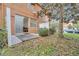 Private patio with sliding glass door access, small yard with gravel and some trees at 7606 Acklins Rd, Kissimmee, FL 34747