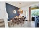 Elegant dining area with modern four-seater table and blue patterned wall at 8891 Geneve Ct, Kissimmee, FL 34747