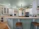 Kitchen with a breakfast bar, white cabinets, and a view into the dining area at 12995 Broleman Rd, Orlando, FL 32832