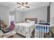 Bright bedroom with a queen-size bed, crib, and workspace at 1917 Michigan Drive, Poinciana, FL 34759