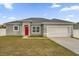 One-story home with gray exterior, red door, and two-car garage at 1917 Michigan Drive, Poinciana, FL 34759