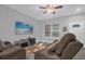 Living room with brown couches, large TV, and ceiling fan at 1917 Michigan Drive, Poinciana, FL 34759