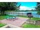 Brick patio with picnic table and grill overlooking a lake at 210 Watling Way # 24-210, Davenport, FL 33897