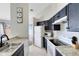 Kitchen with stainless steel sink, white appliances, and dark cabinets at 2516 Woodgate Blvd # 206, Orlando, FL 32822