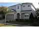 Two-story house with gray siding, three-car garage, and landscaping at 289 Auburn Ave, Kissimmee, FL 34747
