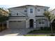 Two-story house with gray siding, a three-car garage, and landscaping at 289 Auburn Ave, Kissimmee, FL 34747