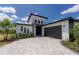 Modern two-story home with a gray paver driveway and attached garage at 326 Spinnaker Ct, Auburndale, FL 33823