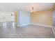 Open dining room with light wood floors, chandelier, and view into adjacent living space at 15352 Perdido Dr, Orlando, FL 32828